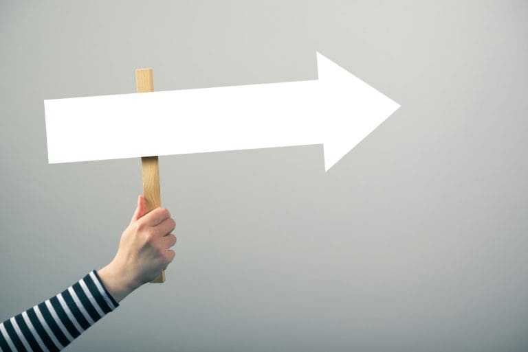 Woman holding guiding direction arrow sign