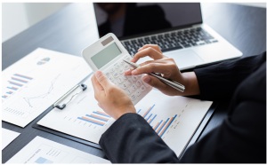 A person using a laptop and calculator to budget
